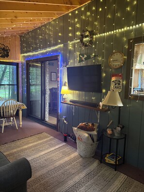 Ein gemütliches Zimmer mit Fernseher, Lampe und Teppich.