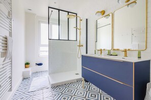 A modern bathroom with a shower, a vanity with a mirror, and a patterned floor. - Luxurious Apartment - 4br/10p- Ternes/pereire (Paris)