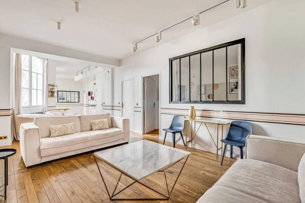 Una sala de estar moderna con sofá, mesa de centro y sillas.
