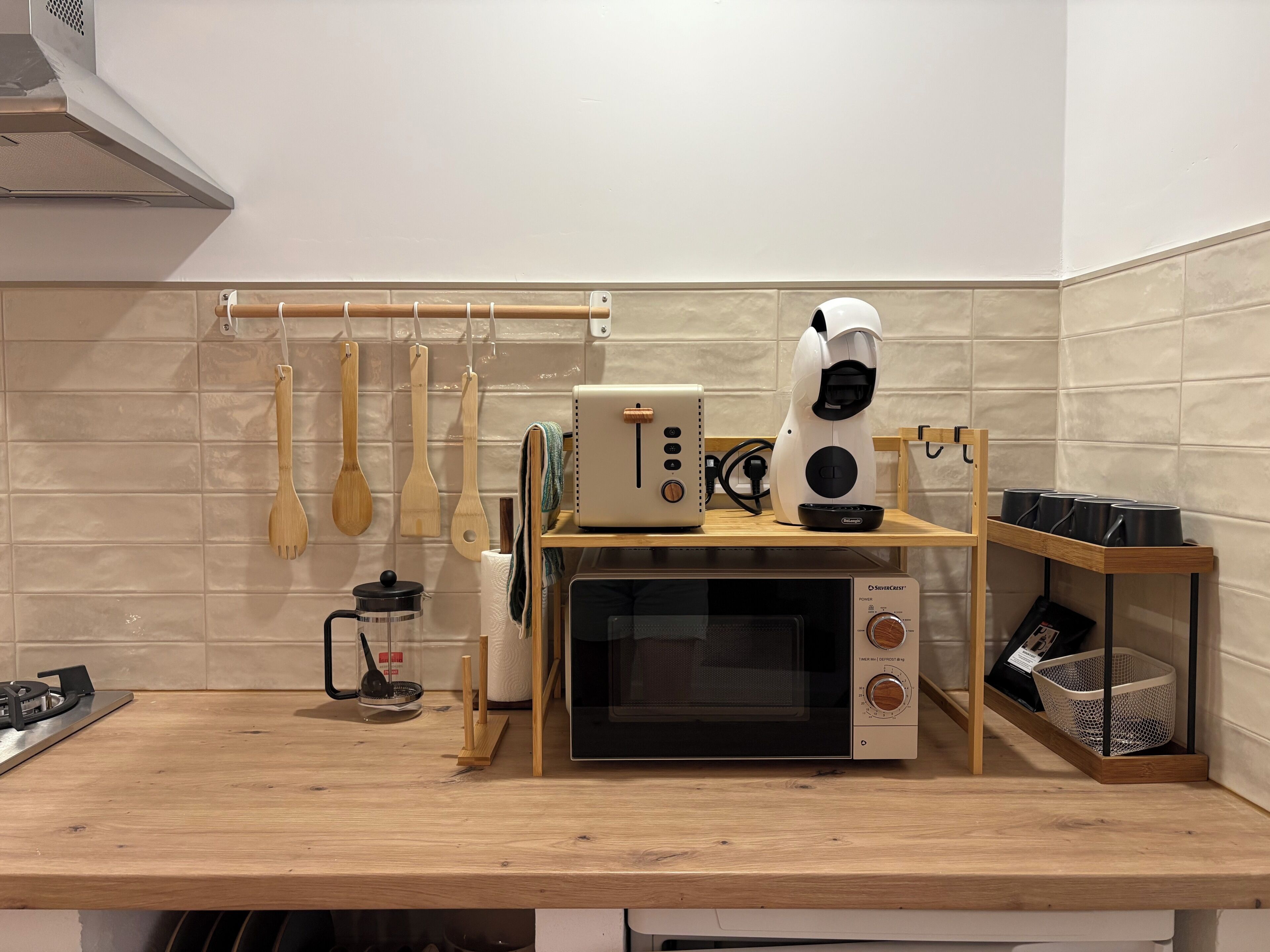 Eine Küche mit Mikrowelle, Toaster und Kaffeemaschine auf einer Holzausziehtafel.