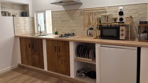 A modern kitchen with wooden cabinets, a stainless steel range hood, a microwave, and a dishwasher.
