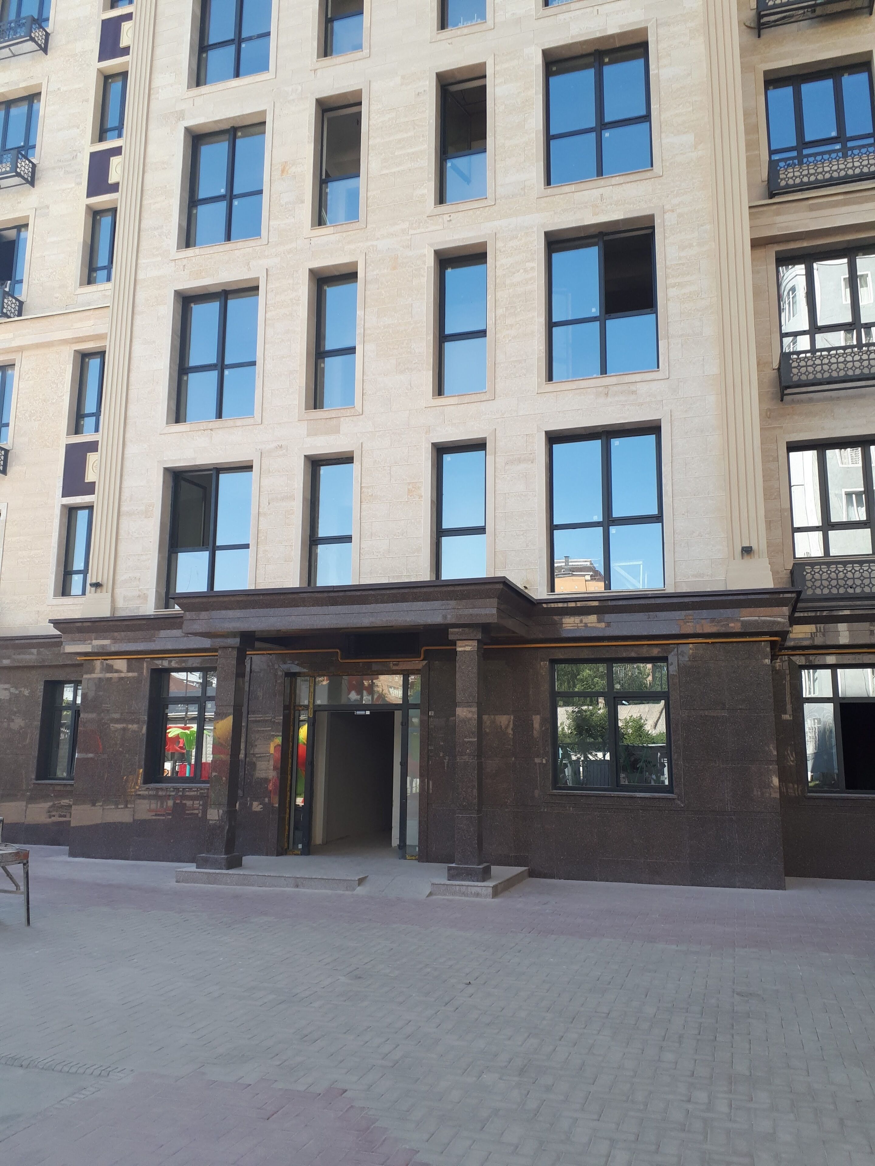 A multi-story building with a modern architectural style, featuring large windows and a central entrance.