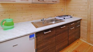 A compact kitchen with a sink, stove, and cabinets. - Comfortable Holiday Home Very Close to the Beach (Ustronie Morskie)