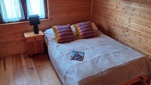 A wooden room with a bed, a nightstand, and a window. - Comfortable Holiday Home Very Close to the Beach (Ustronie Morskie)