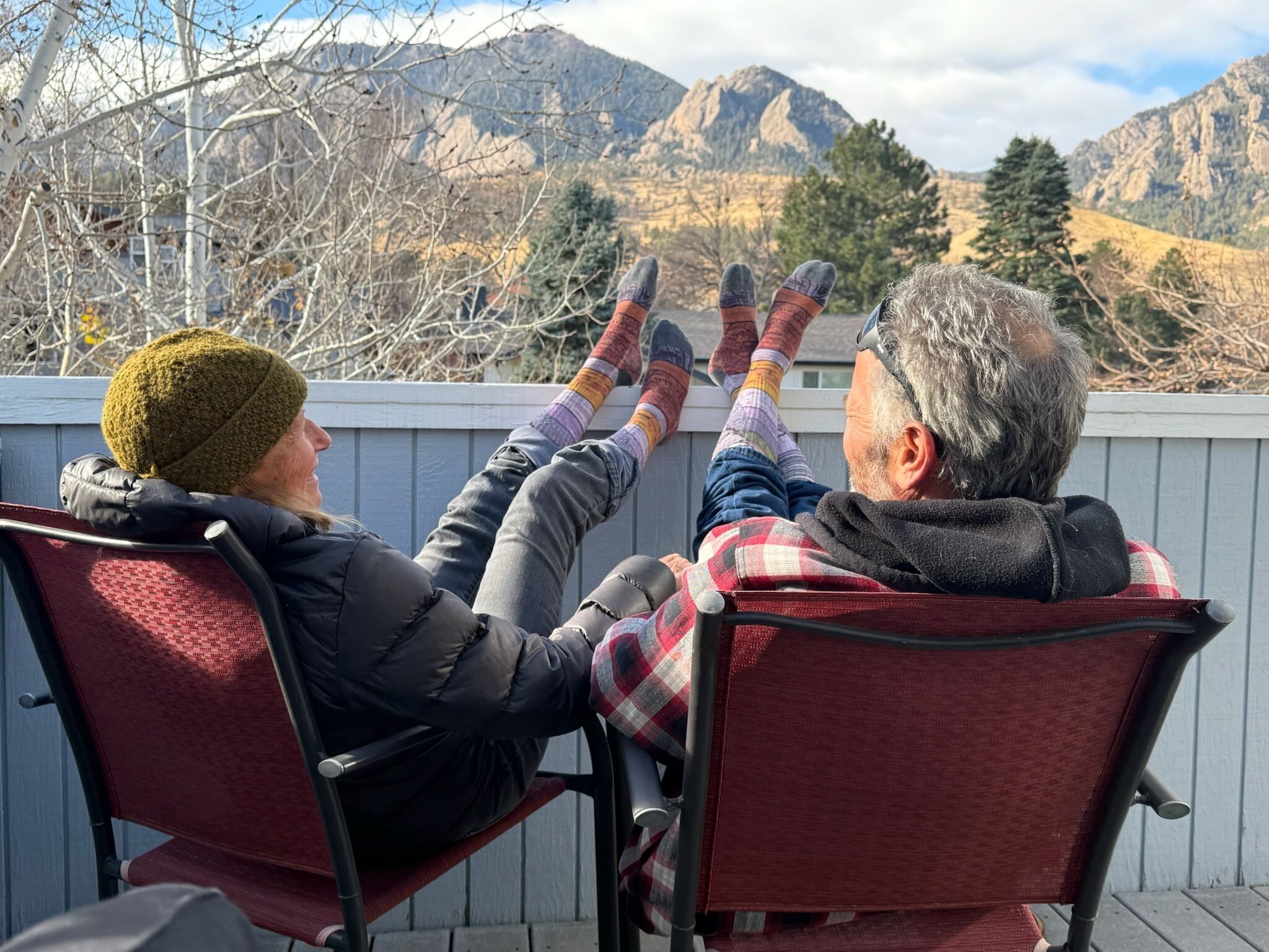 Dos personas sentadas en una terraza con vista a la montaña.