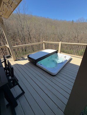 A hot tub on a wooden deck with a view of trees. - 6 ACRES RETREAT SAUNA, HOT TUB, FIRE PIT, GAMES (Jasper)