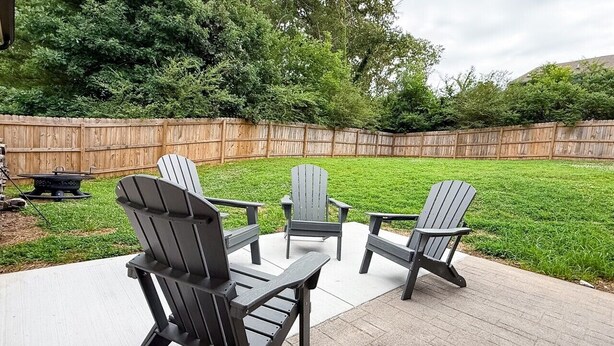 Eine Terrasse mit Adirondack-Stühlen und einem Grill.