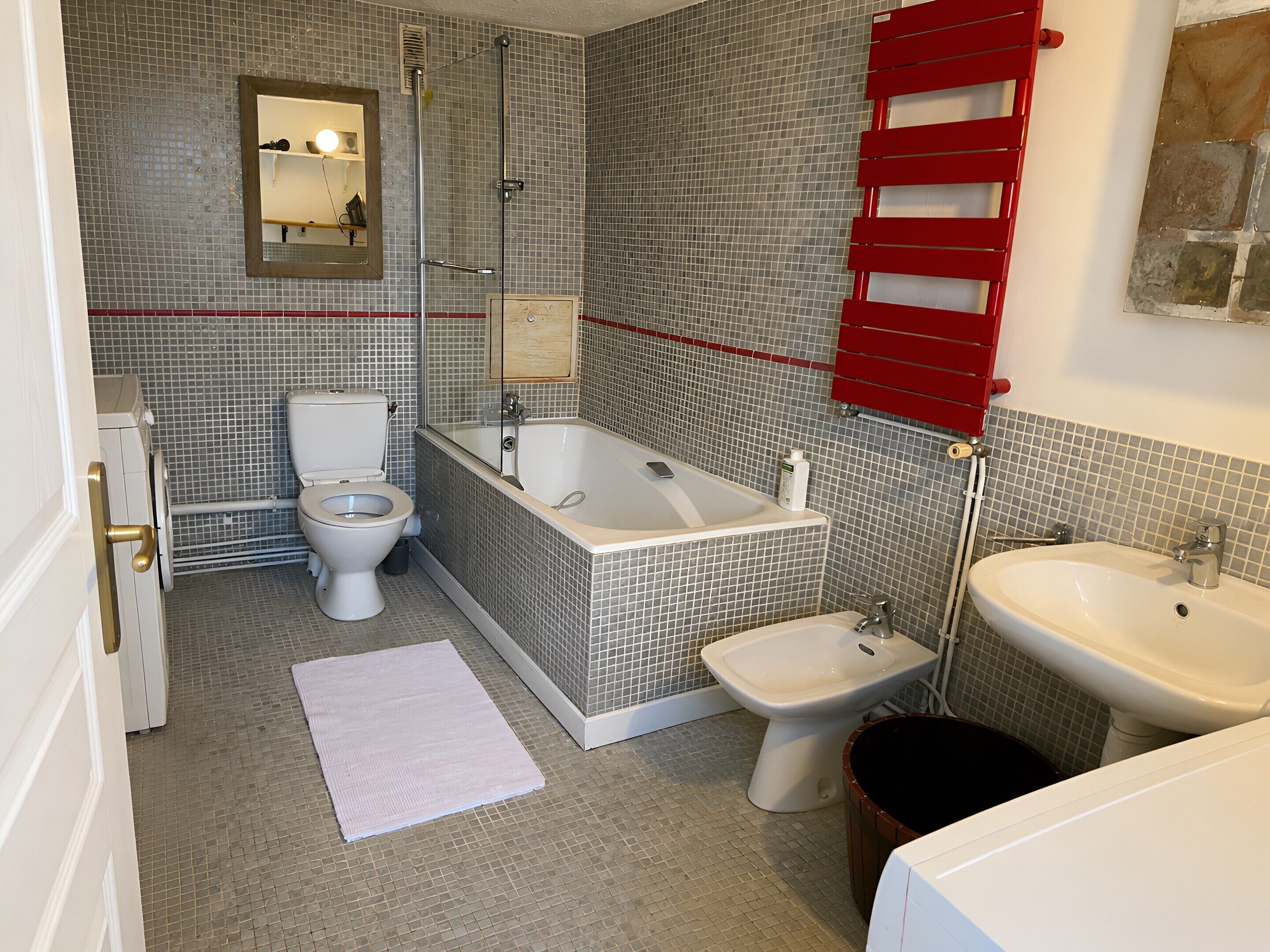 A bathroom with a toilet, bathtub, and sink.