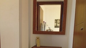 A corner room with a wooden dresser, a mirror, and a door. - Cozy1-bedroom apartment, two sofa bed in enchanting peraia-neoi epivates with AC (Thessaloniki)