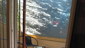 A room with a sliding glass door leading to an outdoor area with a table and chairs. - Cozy1-bedroom apartment, two sofa bed in enchanting peraia-neoi epivates with AC (Thessaloniki)