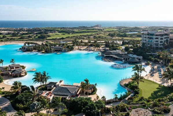 Ein Resort mit mehreren Pools, einem Strandbereich und Blick auf den Ozean.