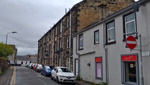 A narrow street lined with parked cars and buildings with stone facades. - 2nd Floor, Train Stn, Beach, Cumbrae-Millport Ferry Port All Under 0.3 Mile. (Largs)