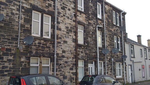 A multi-story stone building with satellite dishes, a car parked in front, and a visible chimney. - 2nd Floor, Train Stn, Beach, Cumbrae-Millport Ferry Port All Under 0.3 Mile. (Largs)