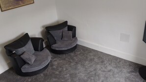 A room with two black chairs, a grey carpet, and a black television on a stand. - 2nd Floor, Train Stn, Beach, Cumbrae-Millport Ferry Port All Under 0.3 Mile. (Largs)