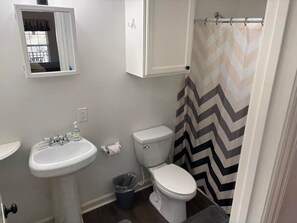 Ein Badezimmer mit Waschbecken, Toilette und Duschvorhang.