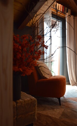 A room with a window, a chair, and a potted plant. - Mountain Suite apartment with a sauna and an open-plan bathtub (Sanzeno)