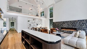 Ein modernes Wohnzimmer mit Kamin, einem weißen Sofa und einer Bar.