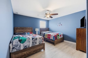 A bedroom with two beds, a ceiling fan, a window, and a TV stand. - 9BR Resort Home for Large Groups with Private Pool Near Disney (Four Corners)