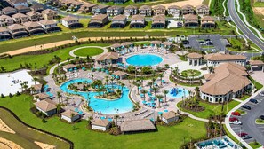 Zona residencial con varias casas, un complejo de piscinas y un aparcamiento.