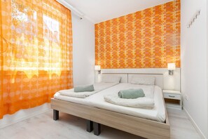 Ein Schlafzimmer mit einem Bett, zwei Nachttischen und einer Wand mit Muster.