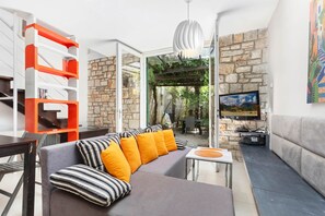 Ein modernes Wohnzimmer mit einer Couch, einem Fernseher und einer Steinwand.