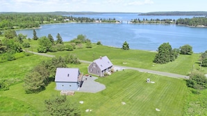 Une vaste propriété comprenant une maison, de grands champs verdoyants et un lac.