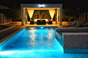 A swimming pool with a covered seating area and lounge chairs. - Holiday Home Valley Breeze (Vrgorac)