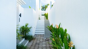 A narrow alleyway with white walls and a brick pathway leading to a staircase. - Dita Villa Uluwatu (Uluwatu)