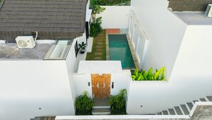 A residential building with a swimming pool, a small garden, and a white exterior. - Dita Villa Uluwatu (Uluwatu)