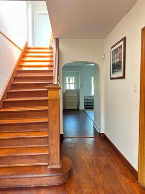 A wooden staircase leading to a hallway with a door at the end.