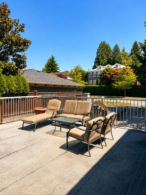 An outdoor patio area with a sofa set, a small table, and a chair.