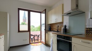 Una cucina moderna con forno integrato, piano cottura e un'ampia finestra con vista sulla città.