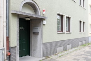 A building with a green door, a mailbox, and a number 4 sign.