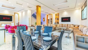 A modern hotel lobby with a dining area, sofas, and a staircase. - Fabulous 3-bedroom house with AC in vibrant Marrakech (Marrakech)
