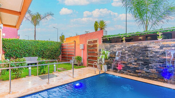 A swimming pool with a stone wall and a metal railing. - Fabulous 3-bedroom house with AC in vibrant Marrakech (Marrakech)