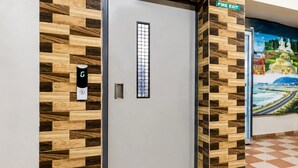 Habitación de hotel con mostrador de recepción, señal de salida de incendios y un mural en la pared.