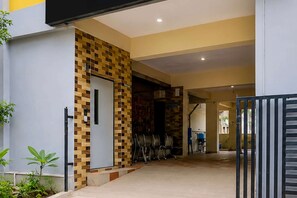 A modern building entrance with a tiled wall, a door, and a gate. - Hotel O Visakhapatnam Railway Junction (Visakhapatnam)