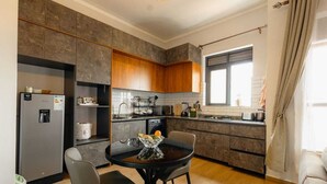 A modern kitchen with a dining area, built-in cabinets, and a window. - Cozy Lake View Haven (Kampala)