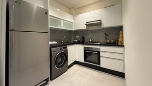 A modern kitchen with stainless steel appliances, a built-in washer, and a gas stove. - Elegant Stay - Les Acacias - Guéliz City Center (Marrakesh)