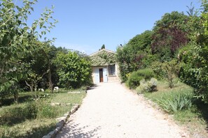 A pathway leading to a building with a door and windows, surrounded by greenery. - HOUSE OF CONSOLATION Small villa adjacent to the Temple of Consolation (Todi)