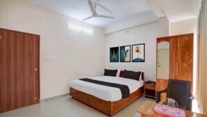 A bedroom with a bed, a ceiling fan, and a wooden wardrobe. - Classic Townhouse Nagawara Junction (Bengaluru)