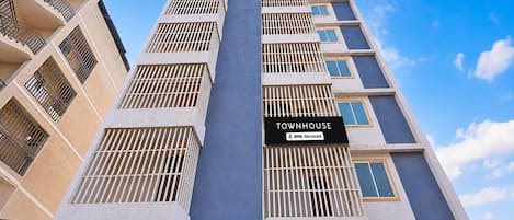 A multi-story building with a sign indicating it is serviced by OYO.