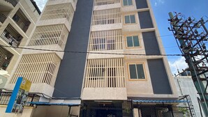 A multi-story building with barred windows, a gated entrance, and visible electrical infrastructure. - Classic Townhouse Nagawara Junction (Bengaluru)