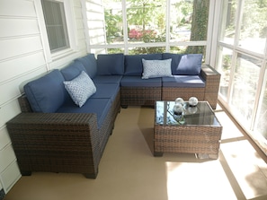 A sectional sofa with blue cushions and a glass coffee table with decorative items. - Quiet Forest Hill/Restaurant/James River/Byrd Park (City of Richmond)