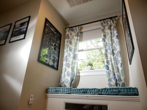 A room with a window, a cushion, a plant, and framed pictures on the wall. - Quiet Forest Hill/Restaurant/James River/Byrd Park (City of Richmond)