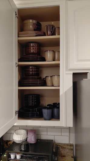 A kitchen cabinet with shelves holding various dishes and cookware. - Quiet Forest Hill/Restaurant/James River/Byrd Park (City of Richmond)