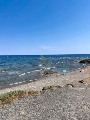 A pebbly beach with a clear sky and calm sea. - L'Escapade Carpeaux (private home) - Sleeps 5, Wi-Fi, patio, parking (Fréjus)