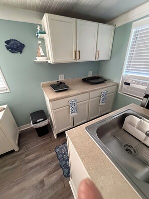 A compact kitchenette with a sink, countertop, and cabinets. - Peaceful room with kitchenette in peaceful Homosassa w/boat parking on premises. (Homosassa)