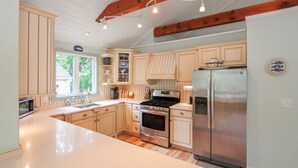 A kitchen with wooden cabinets, a stainless steel refrigerator, a stove, and a sink. - South Chatham Gem - .4 Mile to Pleasant Street Beach (South Chatham)