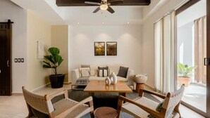 A modern living room with a sofa set, a coffee table, and two wooden chairs. - Urban by Pardela (Puerto Vallarta)